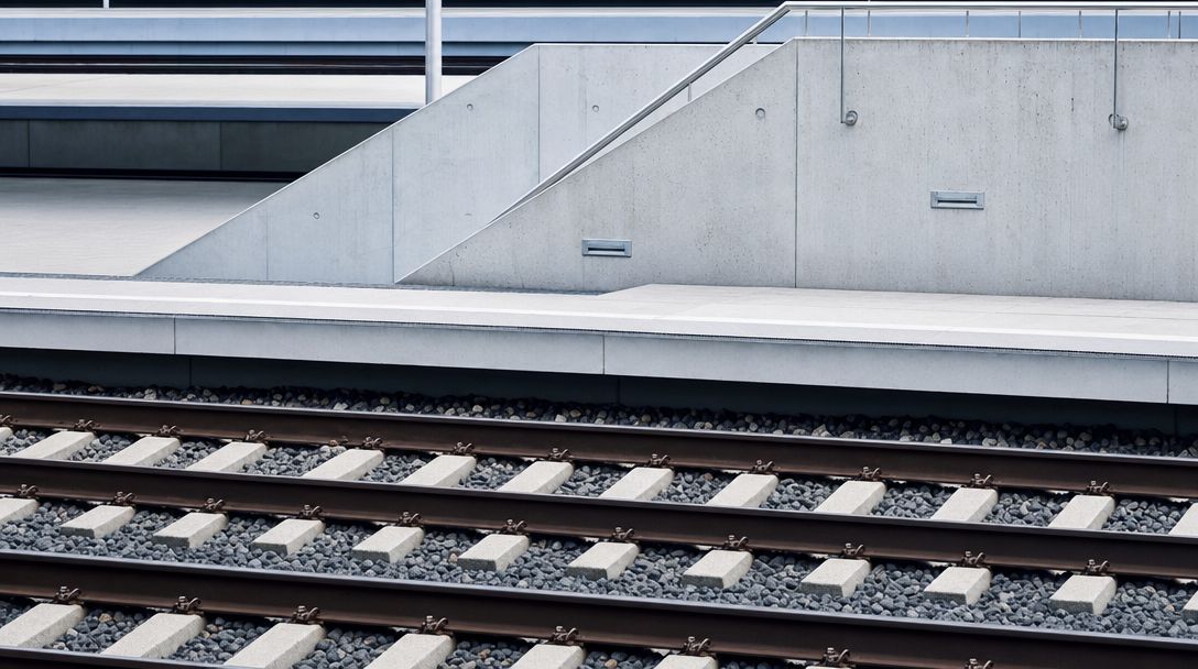 Leere Bahnsteig- und Schienenstruktur mit klarer Geometrie.